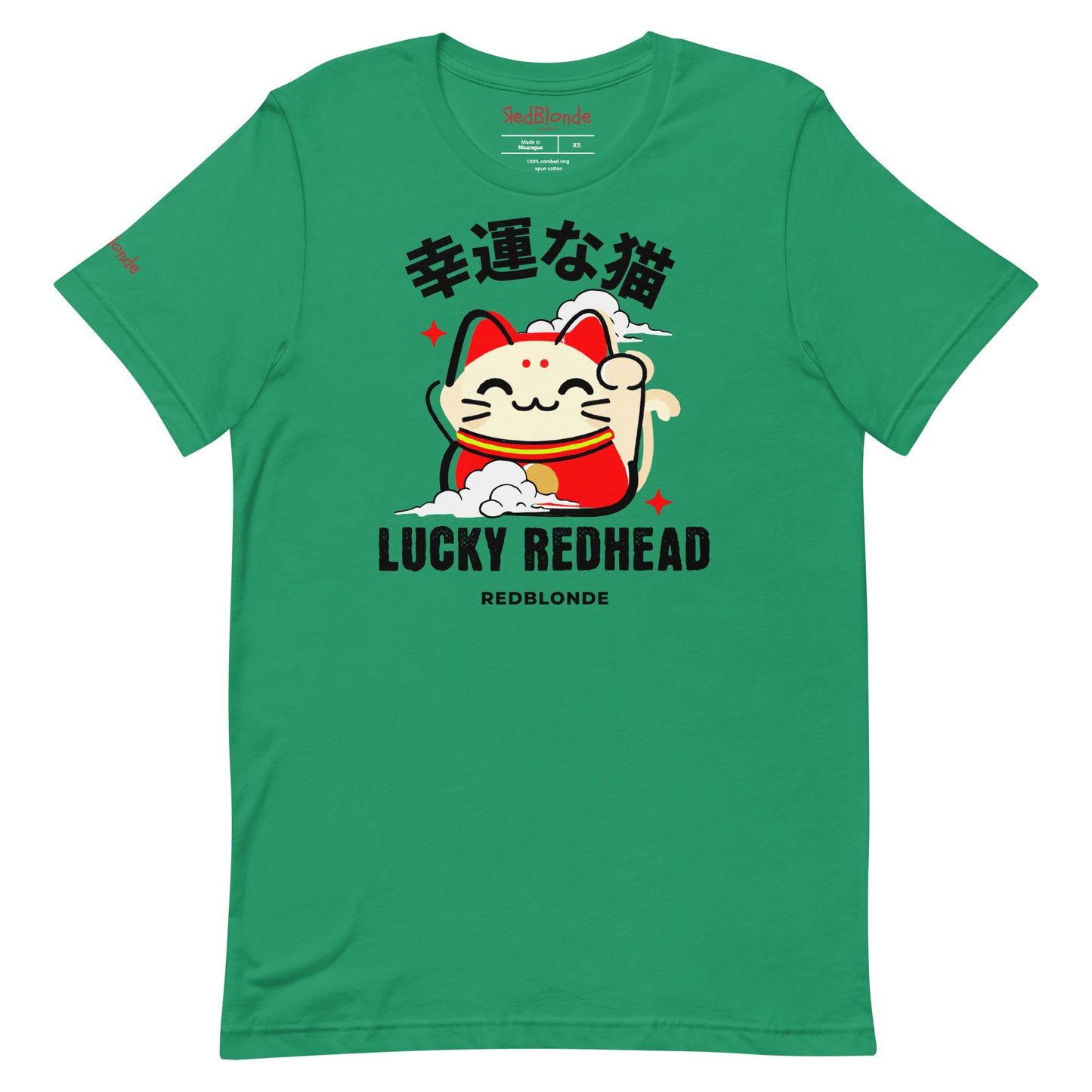 A kelly green unisex T-shirt featuring a colorful maneki-neko (lucky cat) graphic wearing a red outfit with gold accents. Above the cat, Japanese kanji characters are printed in bold white. Below the illustration, the text reads “LUCKY REDHEAD” in distressed white font, with “REDBLONDE” in smaller uppercase letters underneath. The shirt has short sleeves, a classic crew neckline, and a casual, modern fit.