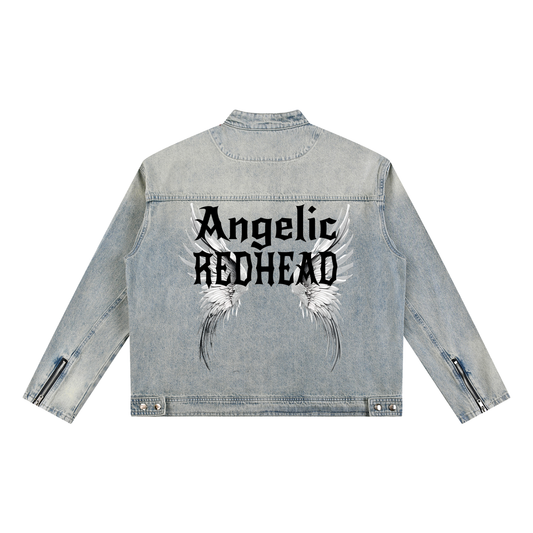 A light-wash denim jacket shown from the back on a white background. The sleeves have zippered cuffs, and the back features a large graphic with white angel wings and black gothic New Rocker style text reading “Angelic REDHEAD.”