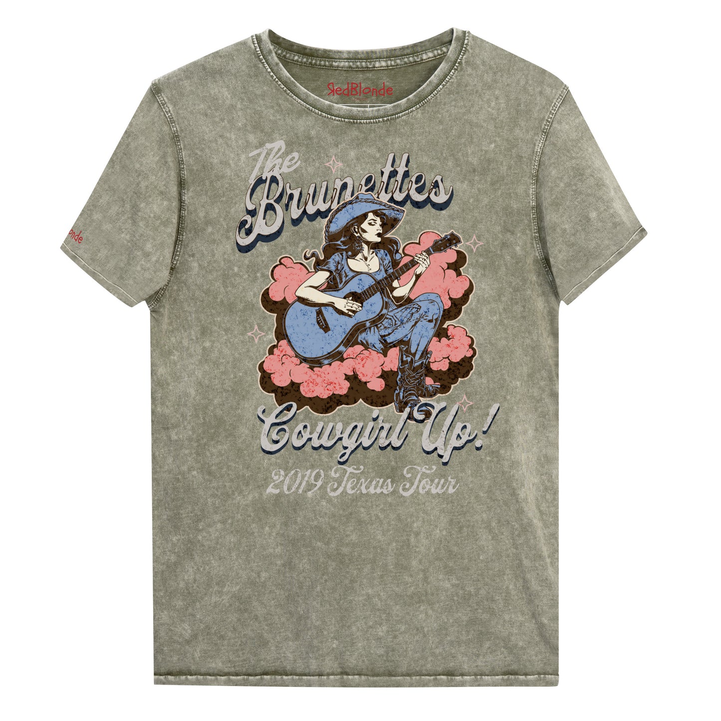 Army Green unisex t-shirt with a faded wash, featuring a retro graphic of a cowgirl playing a guitar surrounded by pink clouds. Text reads 'The Brunettes – Cowgirl Up! 2019 Texas Tour' in a Western-style font. Branded RedBlonde London on the inside neck and right sleeve