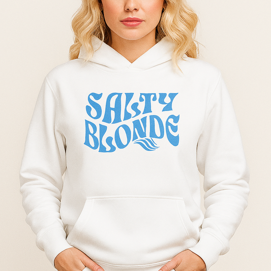 Blonde wears a Classic relaxed fit unisex hoodie in white with 'Salty Blonde' play on words slogan in blue retro 70s wavy text. branded redblonde on inside neck and right shoulder in red