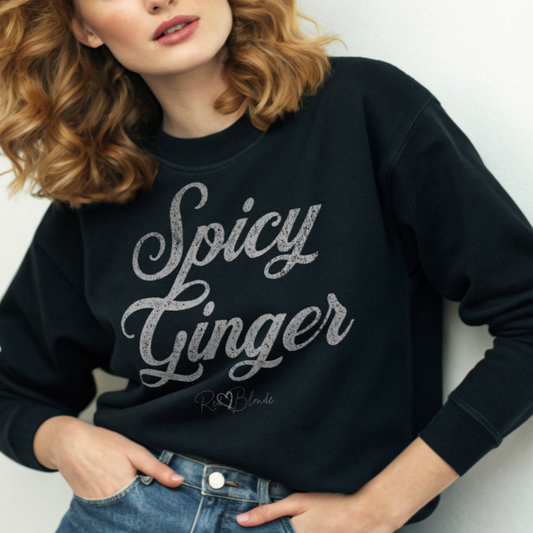 Blonde wears a black Classic relaxed fit premium unisex sweatshirt with the playful slogan ‘Spicy Ginger’ in white milk-store font, signed off RedBlonde. Branded RedBlonde London in red on inside neck and right cuff