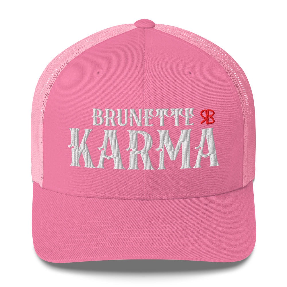 pink/white retro trucker cap with mesh back. The front features bold white embroidered text reading "BRUNETTE KARMA" with a small red RB logo to the right.