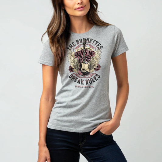 Brunette wears a unisex t-shirt with a burnt pink & beige graphic of a guitar with bird wings emerging from the side. The graphic features ‘THE BRUNETTES’ in Brookfield font above the guitar, ‘STAY TRUE' across the top and 'BREAK THE RULES’ underneath. Branded RedBlonde London in inside neck and right sleeve.