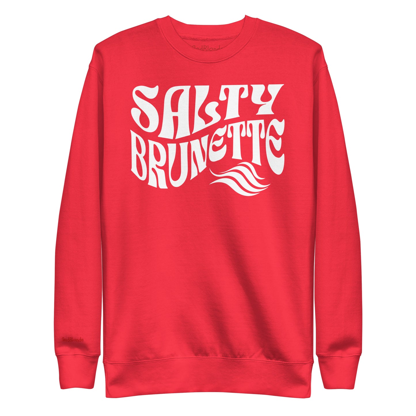 flatlay of Classic relaxed fit unisex sweatshirt in red with 'Salty Brunette' play on words slogan in white retro 70s wavy text. Branded RedBlonde London in red on inside neck and right cuff