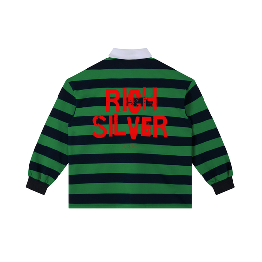 An image showing the back of a long-sleeved rugby polo shirt featuring a pattern of alternating horizontal green and navy stripes. The center of the back displays the words "RICH SILVER" in large, distressed Ed Gein red block lettering, with a smaller signature-style logo printed directly underneath. The shirt is finished with a solid white collar and matching white ribbed cuffs.