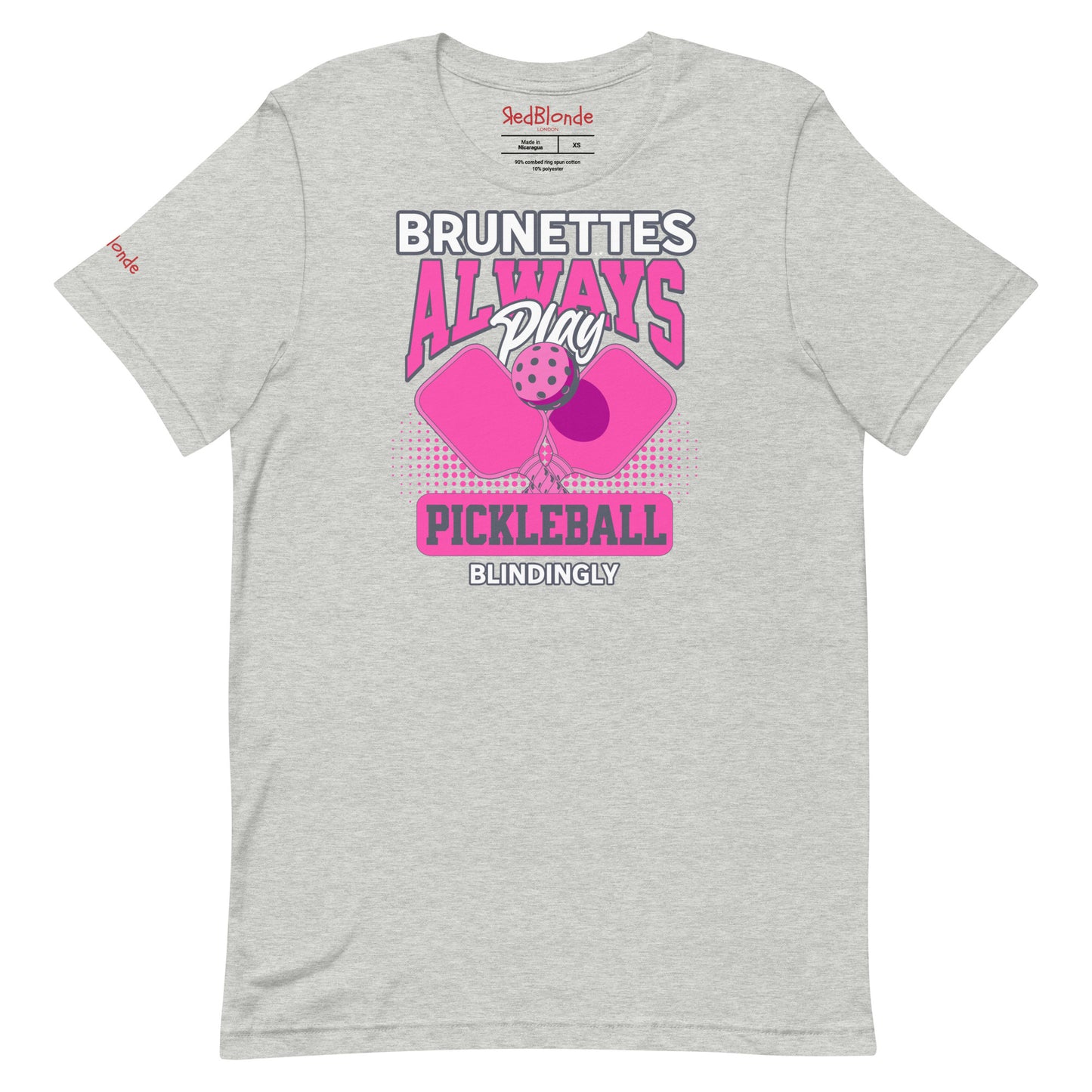 Grey unisex t-shirt with bold pink and white graphic that says "Brunettes Always Play Pickleball Blindingly," featuring two pink pickleball paddles and a ball. Branded RedBlonde on inside neck and right sleeve