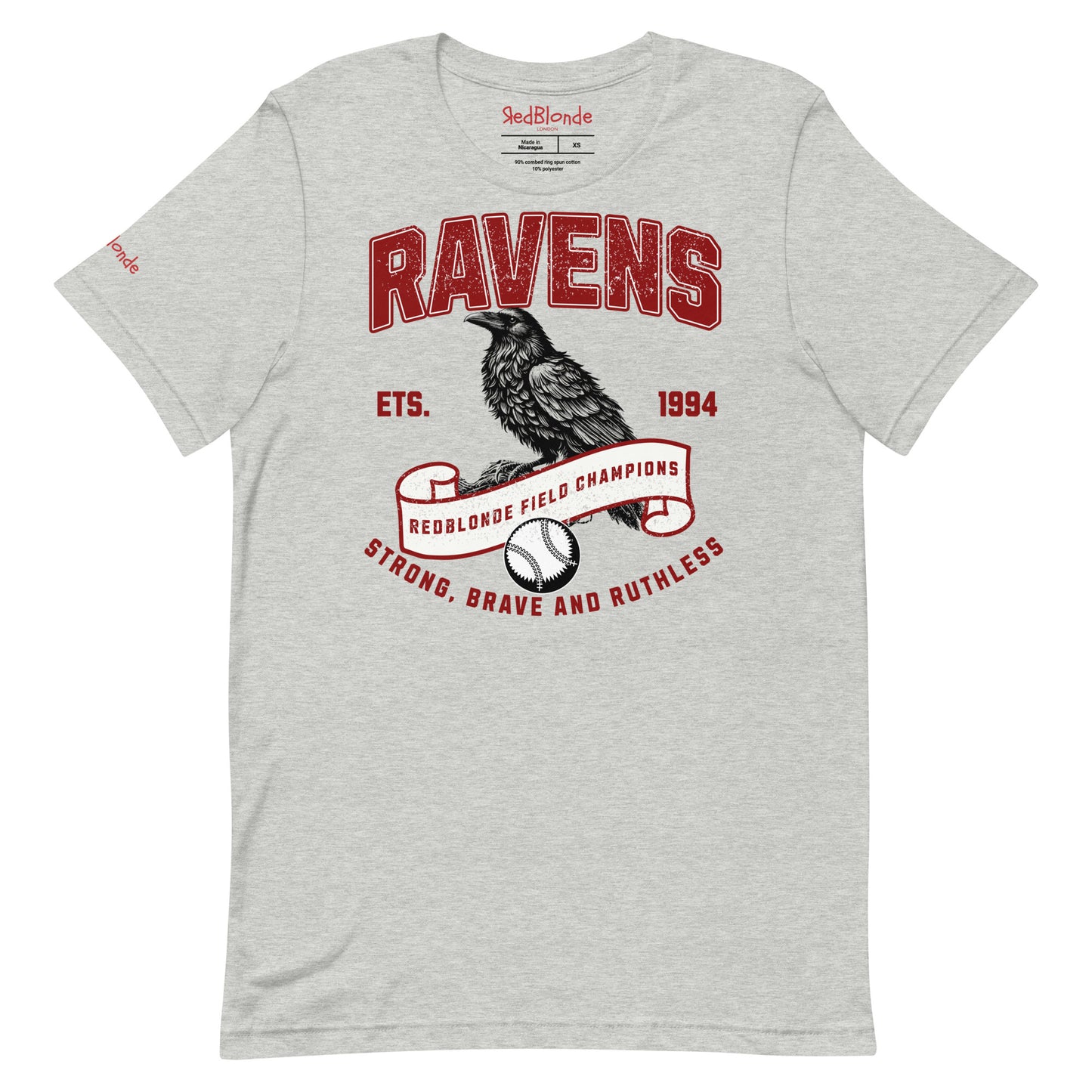 Light grey unisex t-shirt featuring a bold american collegiate vintage-style graphic with the word "RAVENS" in distressed red lettering. Below, a detailed black raven illustration perches on a scroll that reads "REDBLONDE FIELD CHAMPIONS," with a baseball beneath it. Additional text includes "ETS. 1994" and the phrase "STRONG, BRAVE AND RUTHLESS" in red. RedBlonde branding appears on the inner neck label and left sleeve in red text.