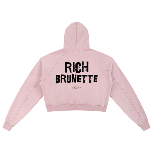Back view of a cropped snow-wash pale pink hoodie with bold black “RICH BRUNETTE” Ed Gein font and the RedBlonde signature logo printed below.