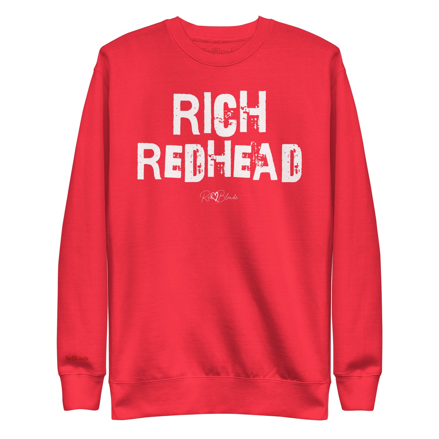 Red unisex premium sweatshirt with bold distressed white Ed Geinitext “RICH REDHEAD” on the front, featuring a subtle RedBlonde logo beneath the lettering and on the sleeve cuff and inside neck
