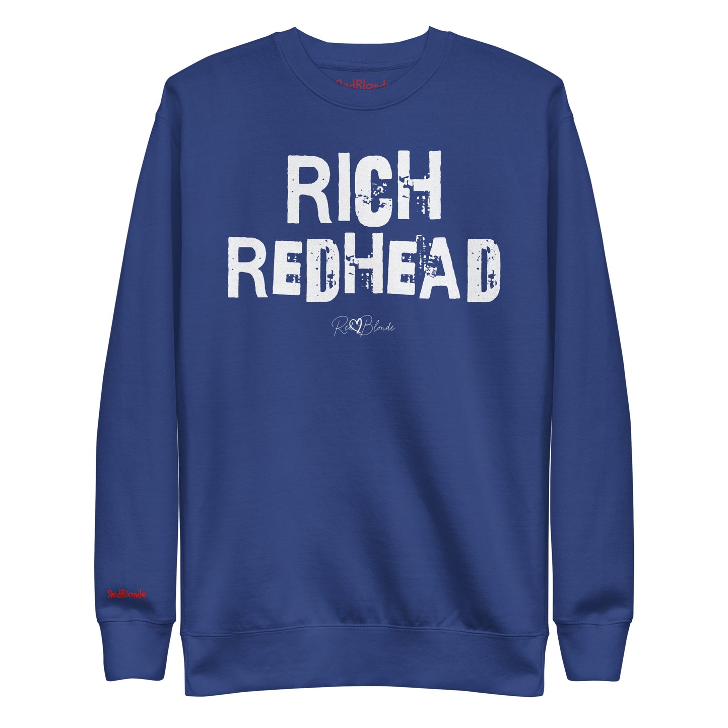 Royal Blue unisex premium sweatshirt with bold distressed white Ed Geinitext “RICH REDHEAD” on the front, featuring a subtle RedBlonde logo beneath the lettering and on the sleeve cuff and inside neck