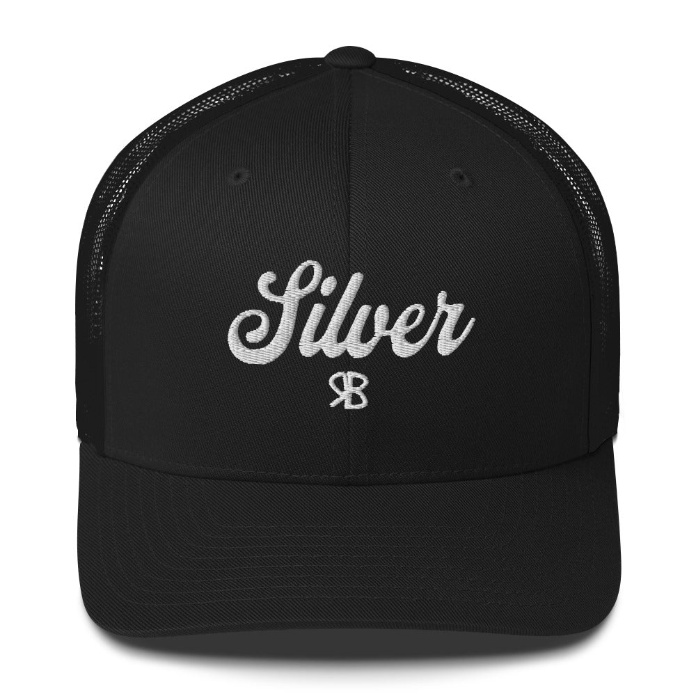 White trucker cap with 'Silver' in white adventurer 01 font on front. Mesh back. Branded RB