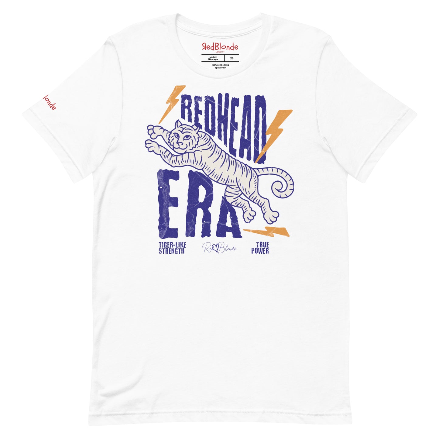White unisex short-sleeve t-shirt featuring a bold graphic of a leaping tiger outlined in purple, surrounded by orange lightning bolts. The text “REDHEAD ERA” appears in large distressed purple letters, with smaller text reading “TIGER-LIKE STRENGTH” and “TRUE POWER” underneath. Signed RedBlonde. The brand name “RedBlonde” is printed in red on the inside collar label and on the right sleeve near the cuff.