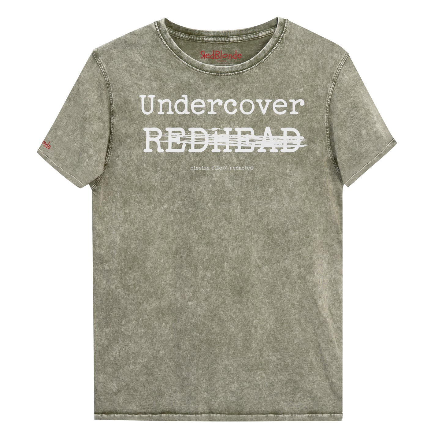 An army green unisex denim-style t-shirt with a vintage washed finish. The front features bold white text reading “Undercover REDHEAD” partially struck through by a horizontal white bar. Beneath it, smaller text says “mission file // redacted” along with a subtle RedBlonde logo. The shirt has a classic crew neck and short sleeves with visible stitching for a rugged look. Branded RedBlonde London in red on inside neck and right sleeve