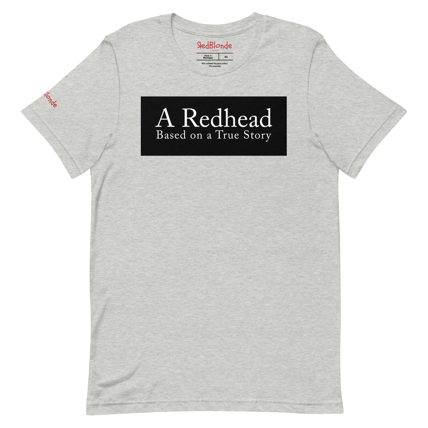 flatlay of a athletic grey unisex relaxed fit t-shirt with the slogan 'A Redhead. Based on a True Story' in white text in a black box graphic. Branded RedBlonde in red on inside neck and right shoulder