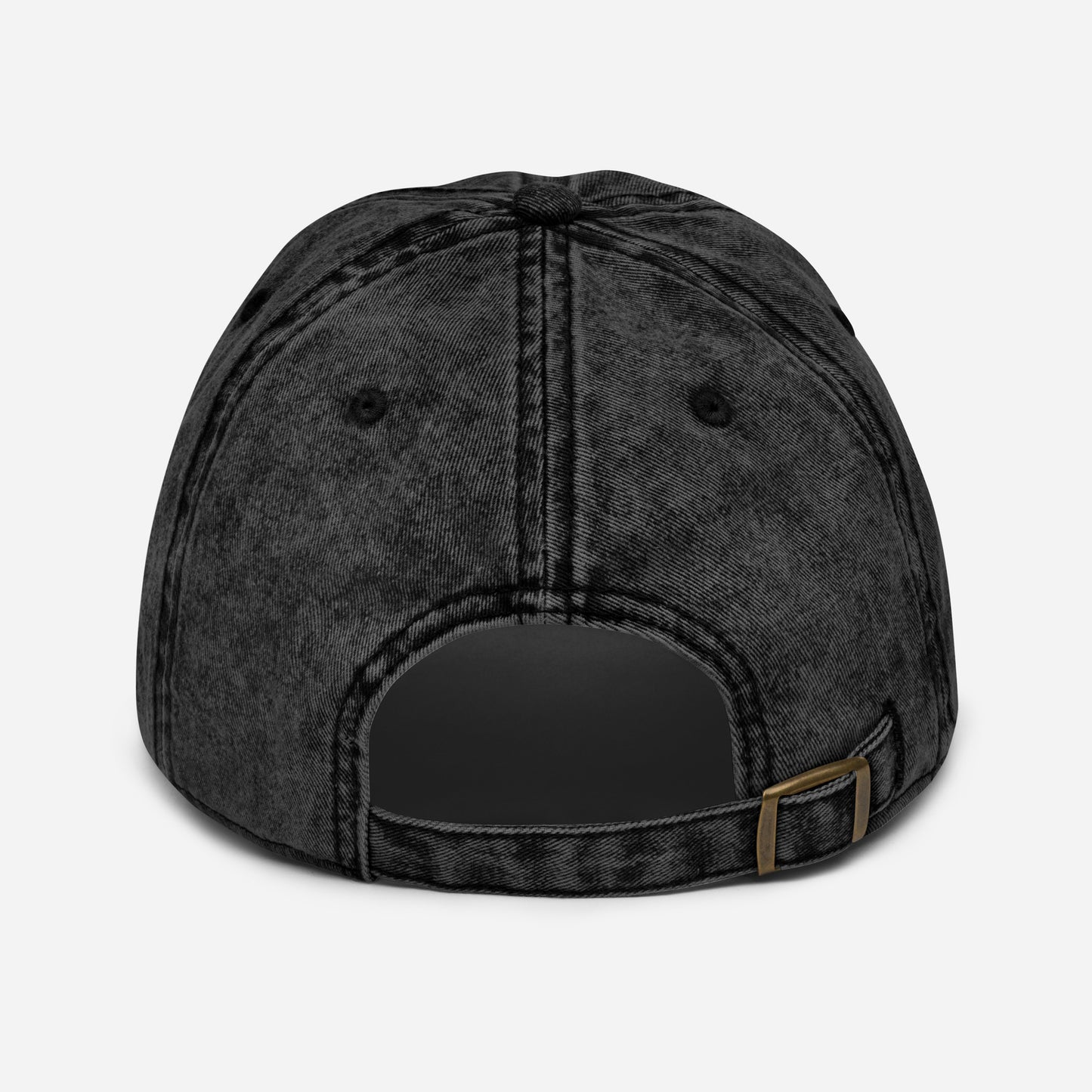 flatlay back view of black denim vintage wash effect baseball cap with antique brass metal adjustable snap buckle