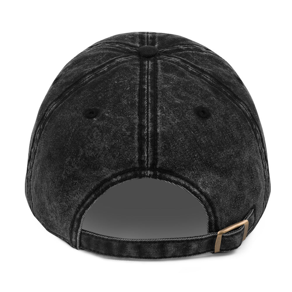 flatlay back view of black denim vintage wash effect baseball cap with antique brass metal adjustable snap buckle