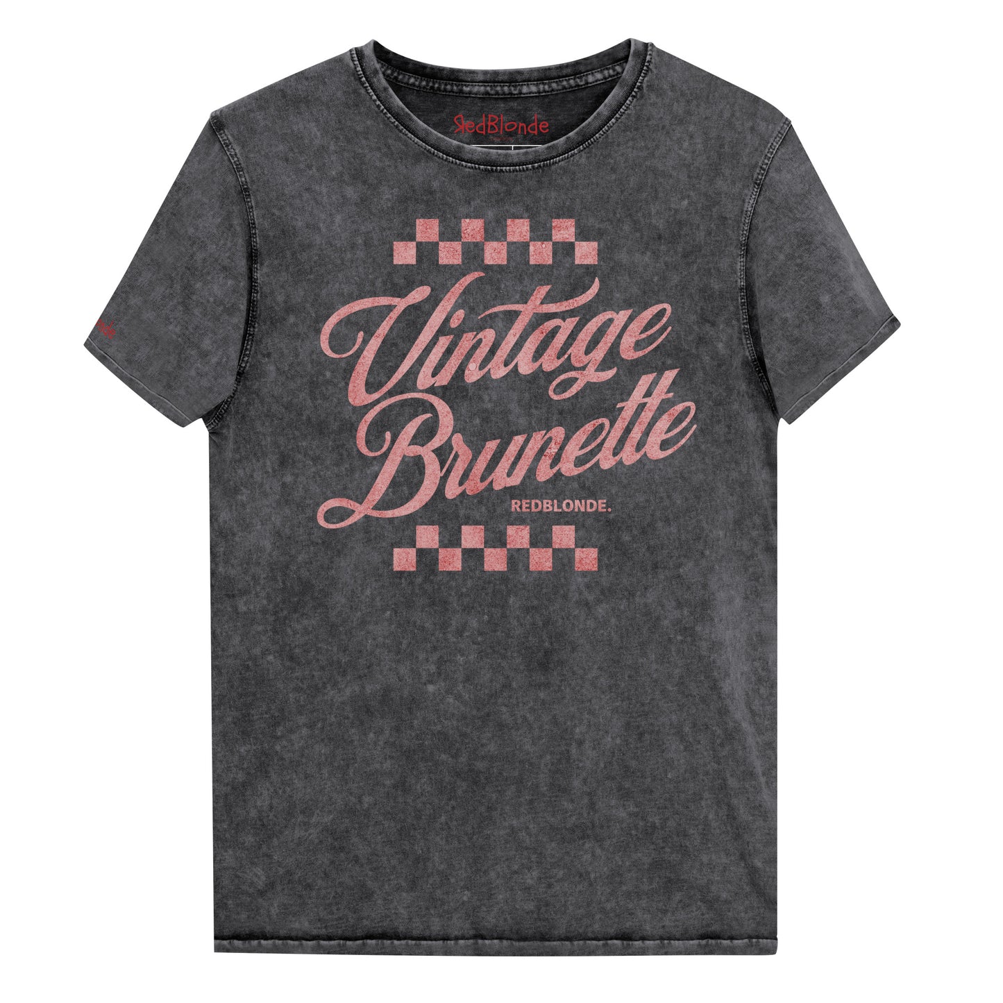 black acid wash short-sleeve T-shirt featuring the bold red Milkstore 1 script text “Vintage Brunette” across the chest with checkerboard accents above and below the lettering. The brand name “RedBlonde.” is printed in small capital letters beneath the word “Brunette.” The shirt has a casual, slightly distressed look with visible stitching along the seams. Branded RedBlonde on inside collar and right sleeve
