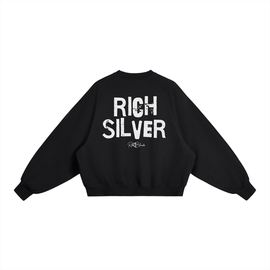 Black oversized dolman-sleeve sweatshirt shown from the back on a plain white background. It has a boxy, relaxed fit with dropped shoulders, ribbed crew neckline, ribbed cuffs, and a ribbed hem band. Centered on the back is a distressed white “RICH BRUNETTE” Ed Gein graphic with a small “RedBlonde” script logo beneath.