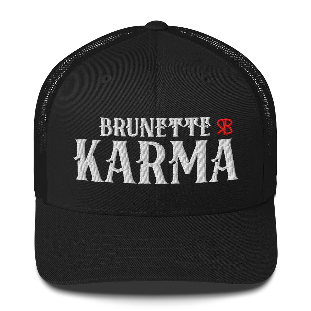 black retro trucker cap with mesh back. The front features bold white embroidered text reading "BRUNETTE KARMA" with a small red RB logo to the right.