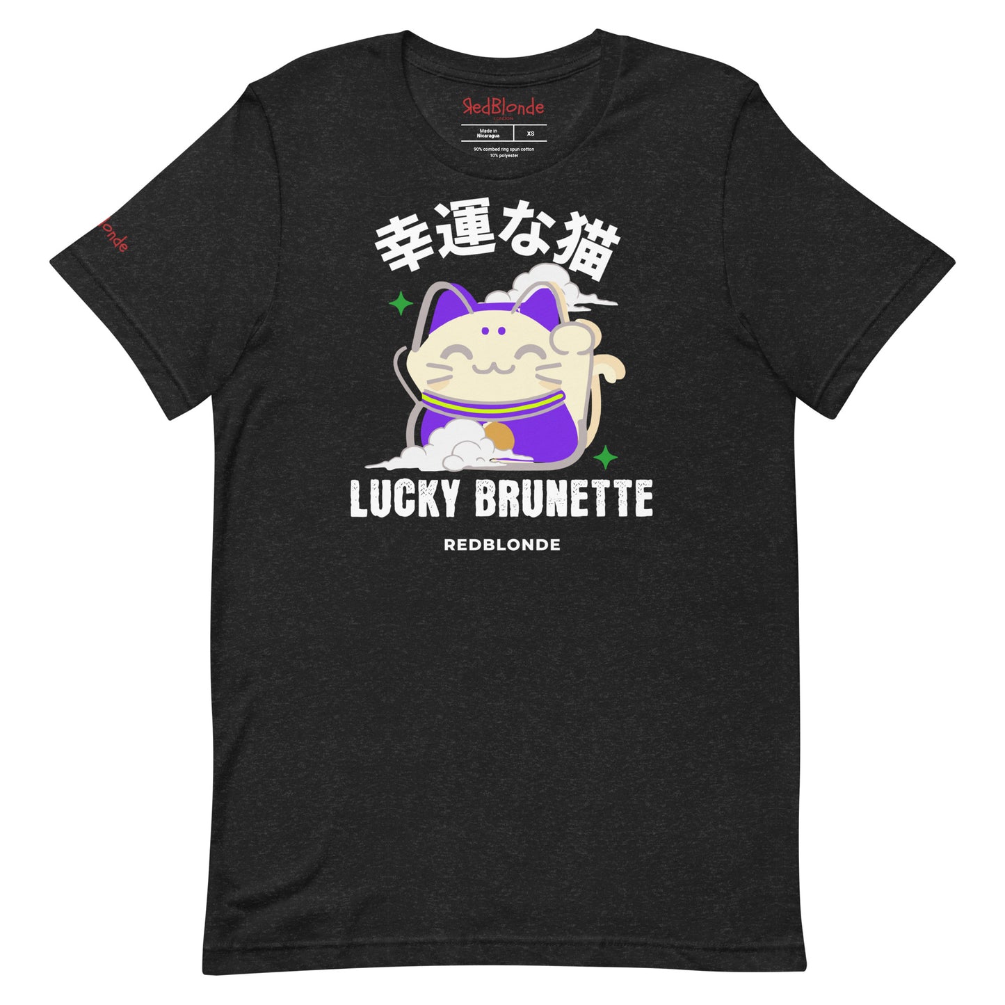 A black unisex T-shirt with a classic crew neckline and short sleeves. The front features a colorful graphic of a waving Maneki-neko (lucky cat) in cream and purple, surrounded by small green sparkles. Above the cat, bold black Japanese characters are displayed. Below the cat, the text reads “LUCKY BRUNETTE” in black block letters, with “REDBLONDE” printed underneath in smaller font. Branded RedBlonde in red inside neck and right sleeve