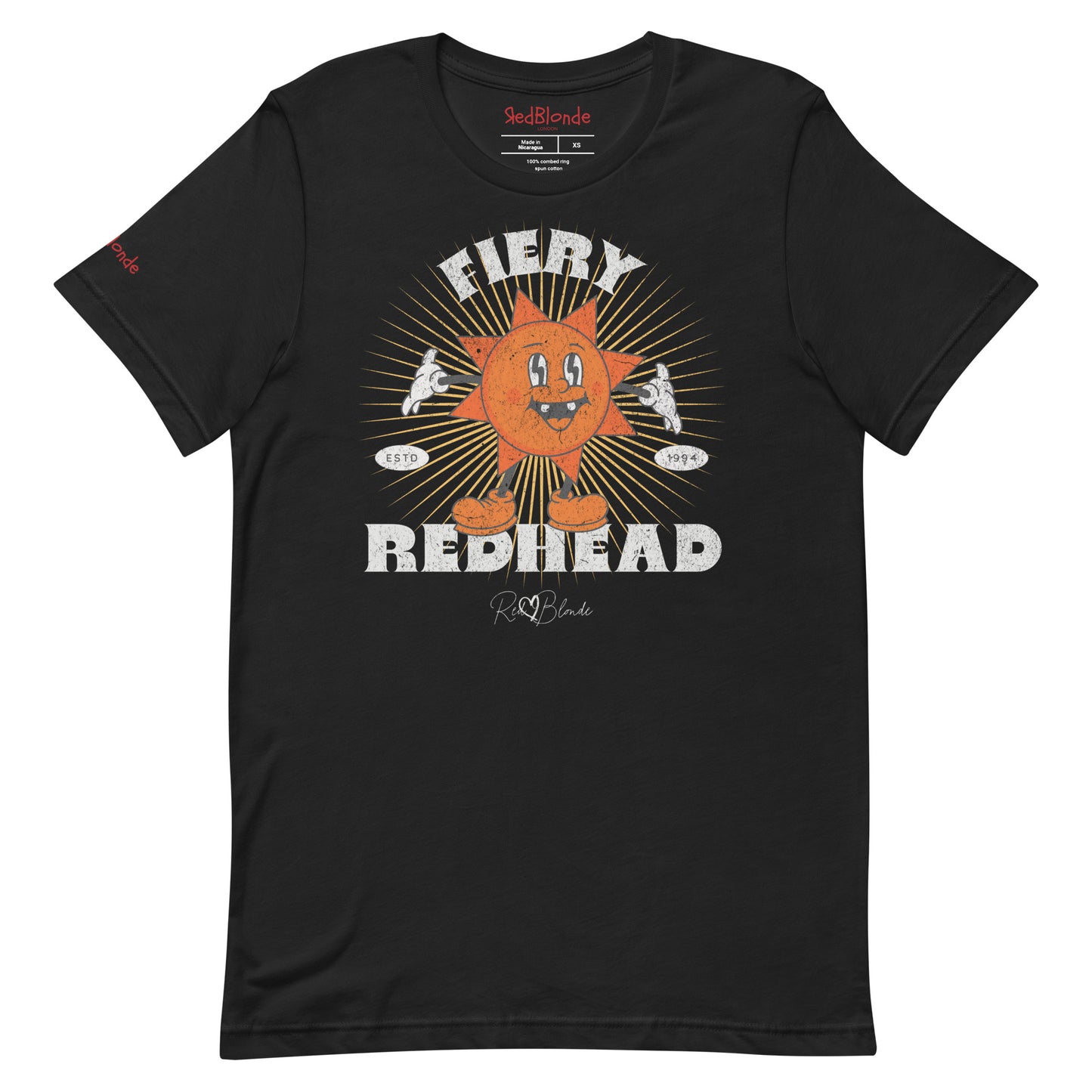 Black unisex crew neck t-shirt with a bold retro graphic of a smiling orange cartoon sun character, surrounded by radiant sunbeams. The text reads ‘Fiery Redhead’ in distressed white Belzebuth lettering with small details including ‘ESTD 1994’ and the RedBlonde signature logo beneath."