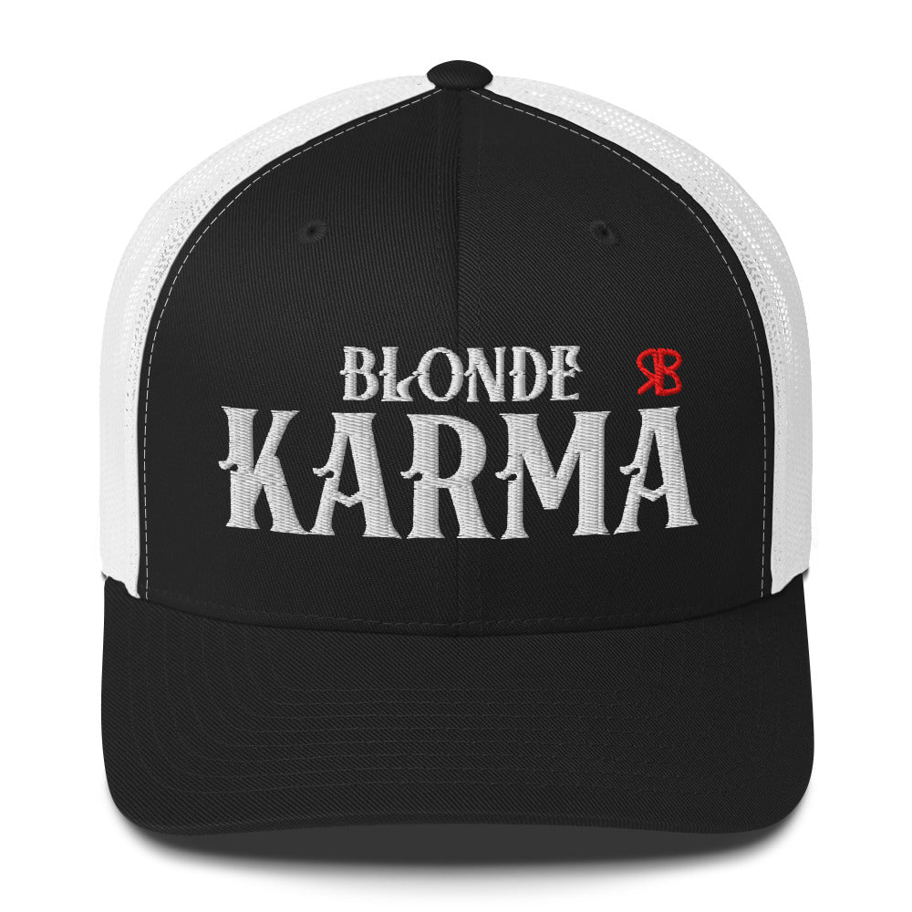 black and white retro trucker cap with mesh back. The front features bold white embroidered text reading "BLONDE KARMA" with a small red RB logo to the right.