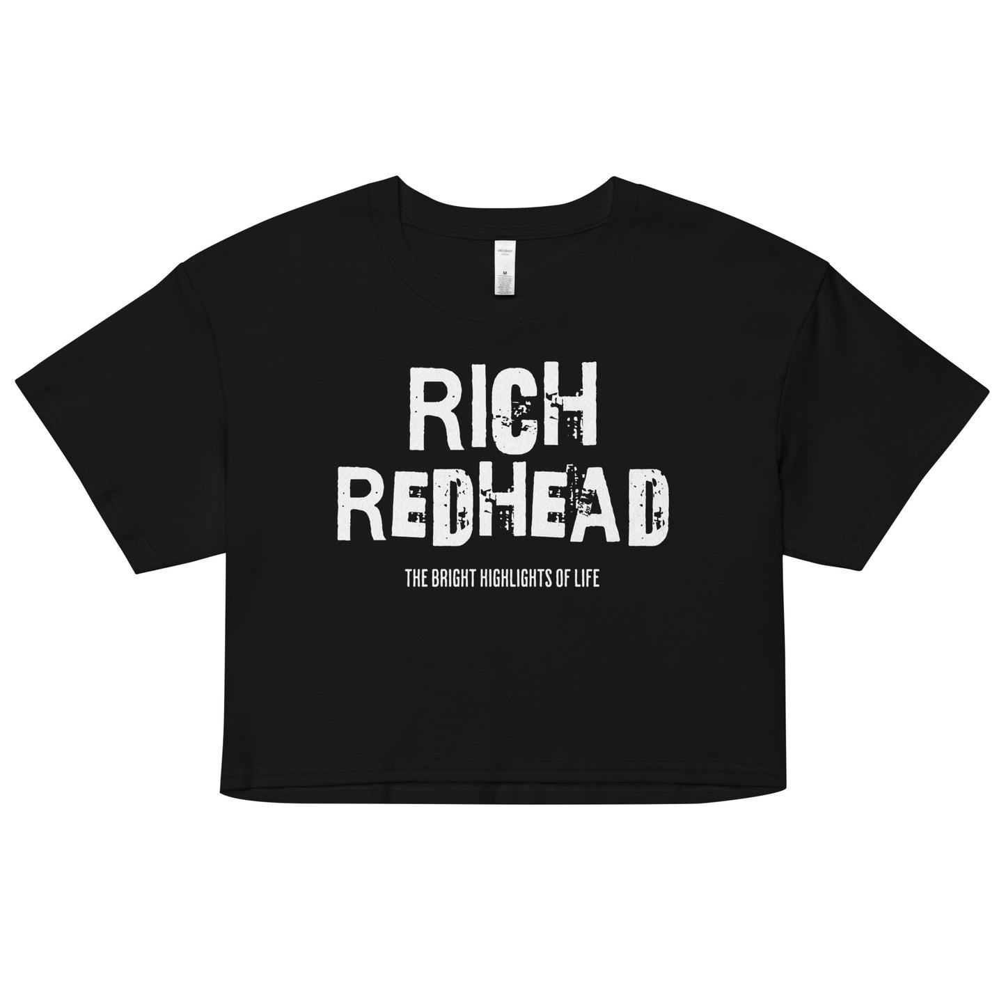 A black women’s crop top with a relaxed fit, short sleeves, and a wide crew neckline. The front features bold white distressed lettering reading “RICH REDHEAD” with the tagline “THE BRIGHT HIGHLIGHTS OF LIFE” in smaller text below.