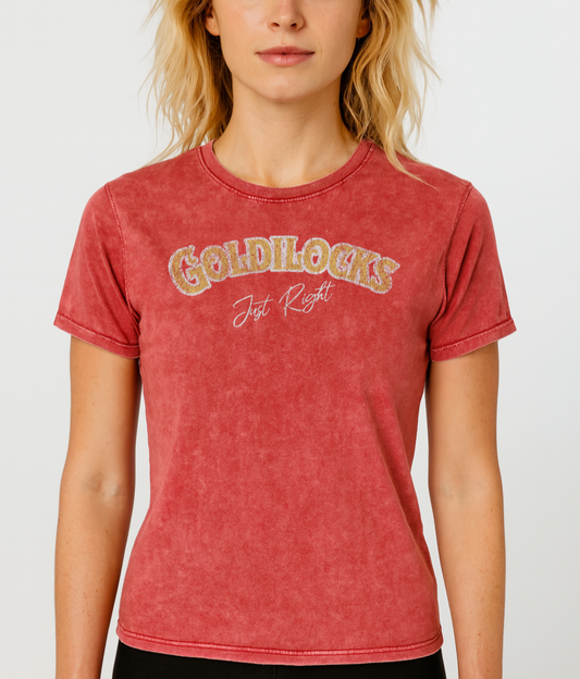 blonde wears Red vintage acid wash look unisex t-shirt with the text “Goldilocks Just Right” in gold and white Signmaster Pro textured font, designed in a bold retro style. Branded RedBlonde on inside neck and right sleeve