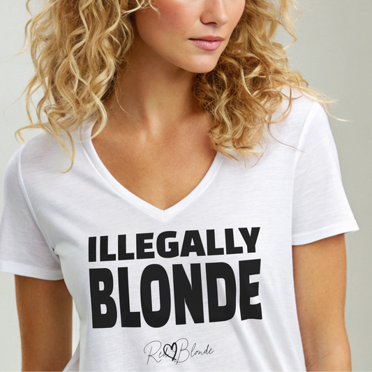 blonde wears a white women’s relaxed V-neck T-shirt featuring black text across the chest that reads “ILLEGALLY BLONDE" in black hans sans font. Beneath the main text is the RedBlonde signature logo in a smaller, cursive style. The shirt has short sleeves, a soft V-neckline, and a casual, comfortable fit. Branded RedBlonde on the inside neck and right sleeve