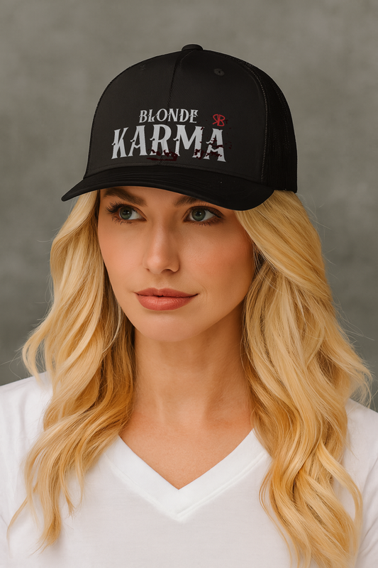 Blonde wears a black retro trucker cap with mesh back. The front features bold white embroidered text reading "BLONDE KARMA" with a small red RB logo to the right.
