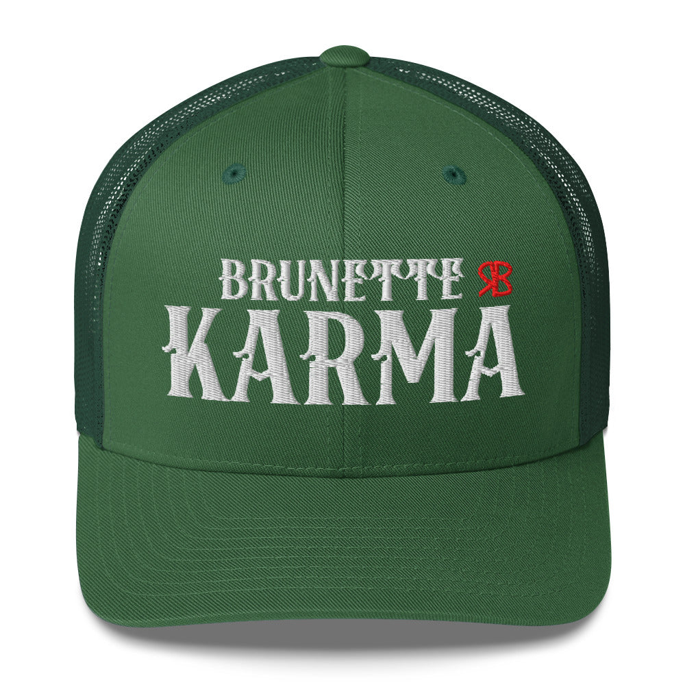 green retro trucker cap with mesh back. The front features bold white embroidered text reading "BRUNETTE KARMA" with a small red RB logo to the right.