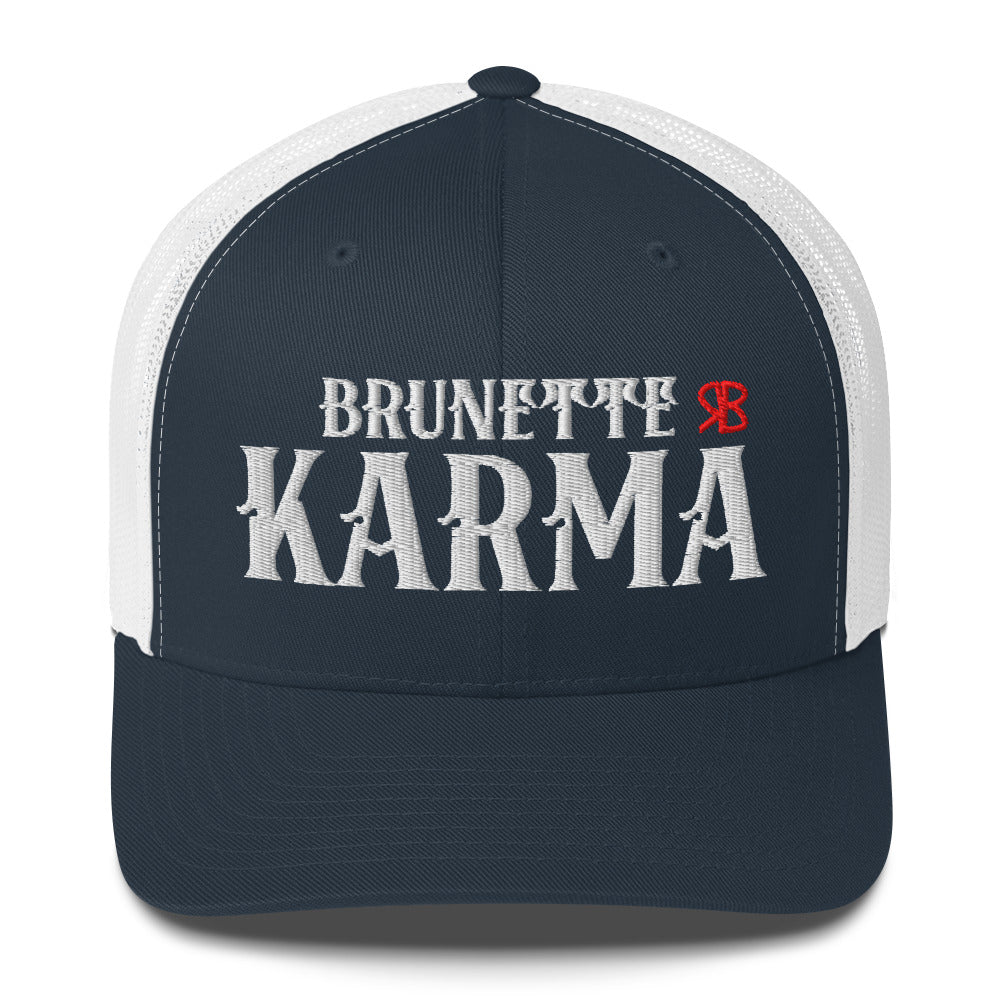 navy/white retro trucker cap with mesh back. The front features bold white embroidered text reading "BRUNETTE KARMA" with a small red RB logo to the right.