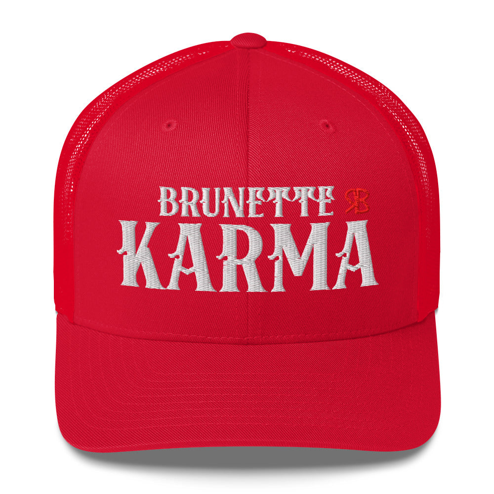 red retro trucker cap with mesh back. The front features bold white embroidered text reading "BRUNETTE KARMA" with a small red RB logo to the right.