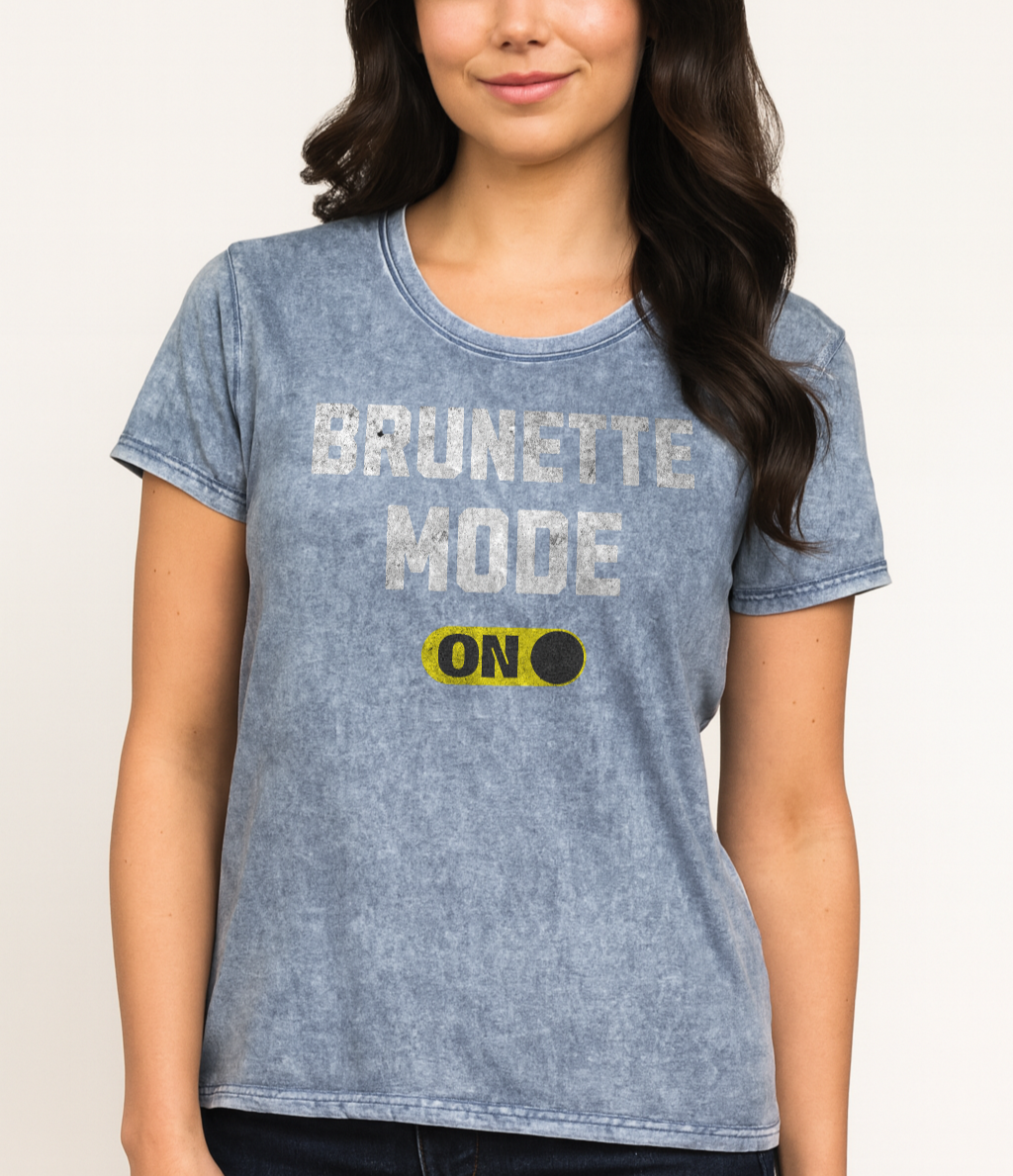 Brunette wears blue denim-style unisex t-shirt with bold distressed white Univercity font reading “Brunette Mode” and a yellow on/off switch graphic in the “On” position beneath. The design includes subtle worn texture for a vintage look. Branded RedBlonde London in red on inside neck and right sleeve