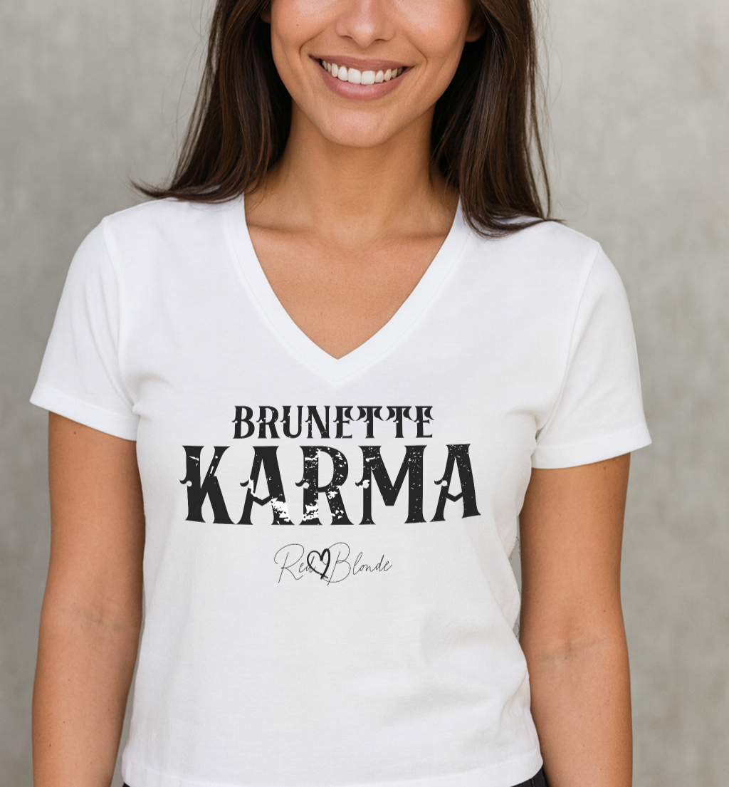 Brunette wears a white v-neck women's relaxed fit t-shirt with 'BRUNETTE KARMA' in Aquero white font, signed RedBlonde. Branded RedBlonde in red on inside neck and right sleeve