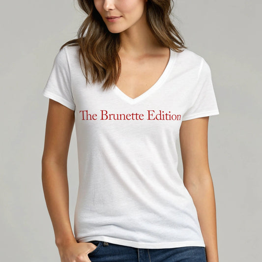 brunette woman wears a relaxed but slightly fitted white v-neck t-shirt with the words 'The Brunette Edition' in red. Branded RedBlonde in red on the inside neck and right sleeve