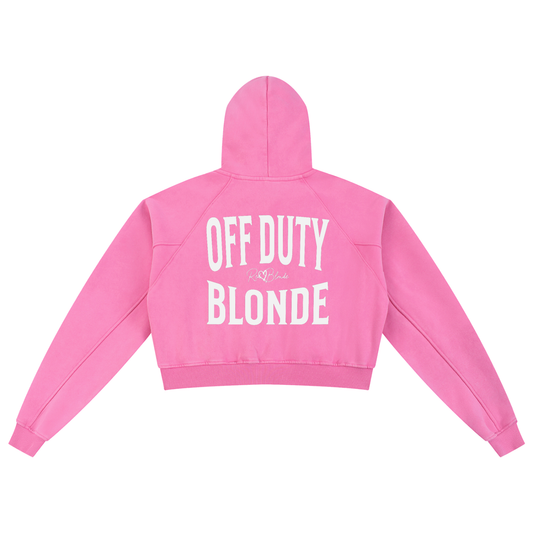 “Back view of a bright pink cropped hoodie with a hood and long sleeves, featuring large white ‘OFF DUTY BLONDE’ text and a small RedBlonde logo on the back.”