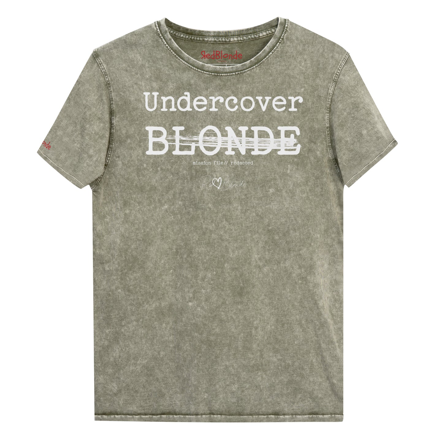 A dark army green unisex denim-style t-shirt with a vintage washed finish. The front features bold white text reading “Undercover BLONDE” with “BLONDE” partially struck through by a horizontal white bar. Beneath it, smaller text says “mission file // redacted” along with a subtle RedBlonde logo. The shirt has a classic crew neck and short sleeves with visible stitching for a rugged look. Branded RedBlonde London in red on inside neck and right sleeve