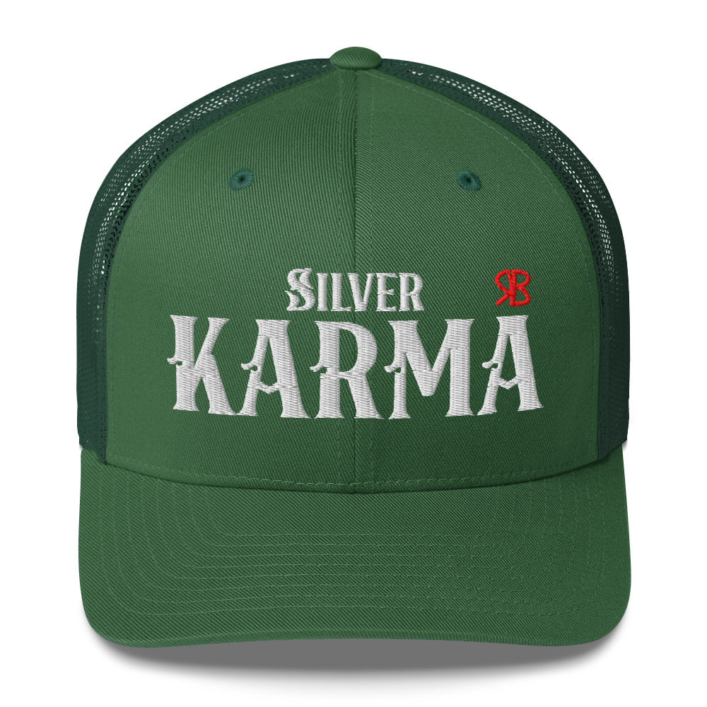 evergreen retro trucker cap with mesh back. The front features bold white embroidered text reading "SILVER KARMA" with a small red RB logo to the right.