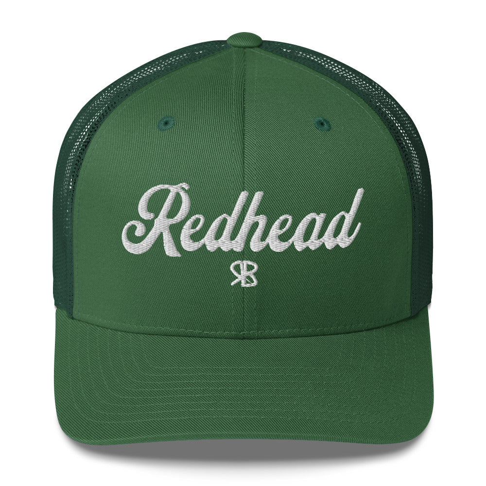 green trucker cap with 'Redhead' in white adventurer 01 font on front. Mesh back. Branded RB