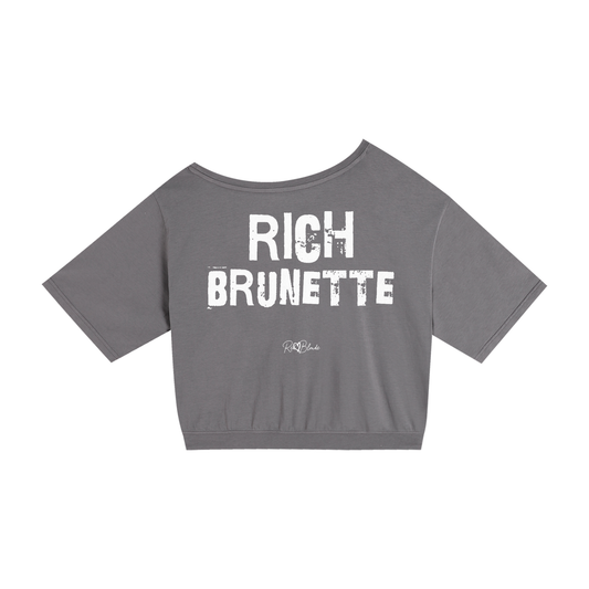 grey asymmetrical shoulder t-shirt with bold white Ed Gein font “RICH BRUNETTE" slogan on the front and RedBlonde logo beneath.