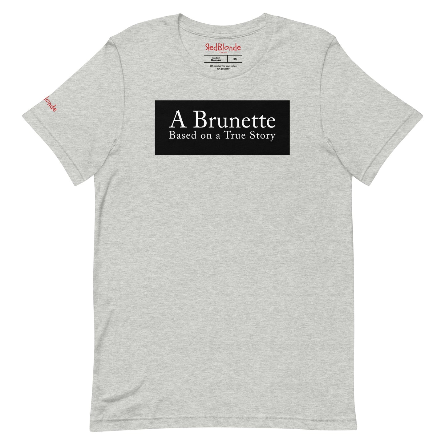flatlay of a heather athletic grey unisex relaxed fit t-shirt with the slogan 'A Brunette. Based on a True Story' in white text in a black box graphic. Branded RedBlonde London in red on inside neck and right sleeve