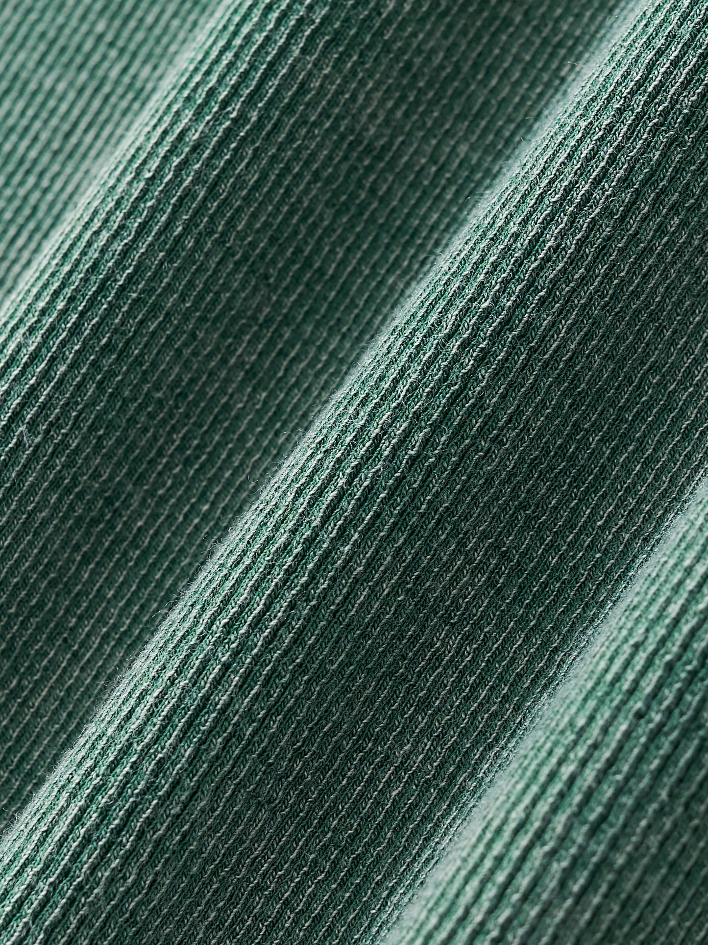 Close-up of textured green fabric with a subtle ribbed texture pattern