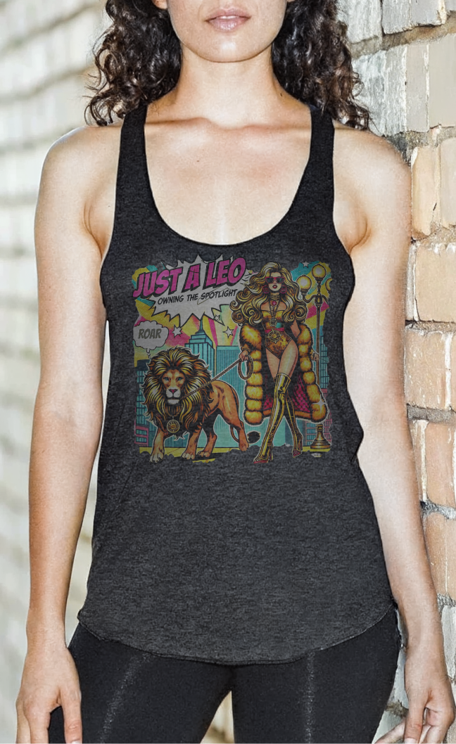 Blacked haired model with hair on her shoulders by a wall wearing black leggings and a heather black soft racerback tank t-shirt with a retro pop-art Leo graphic featuring a long curly haired blonde woman in a gold swimsuit, gold over the knee boots, gold medallion and long fur coat, walking a lion on a leash with a gold medallion with a caption bubble 'Roar', with a city and round bulb street lights in the background captioned ‘Just a Leo, Owning the Spotlight