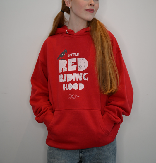 Model wears Red unisex hoodie featuring bold white Love Birds text that reads “Little Red Riding Hood” with a perched raven graphic in black and the RedBlonde logo beneath.