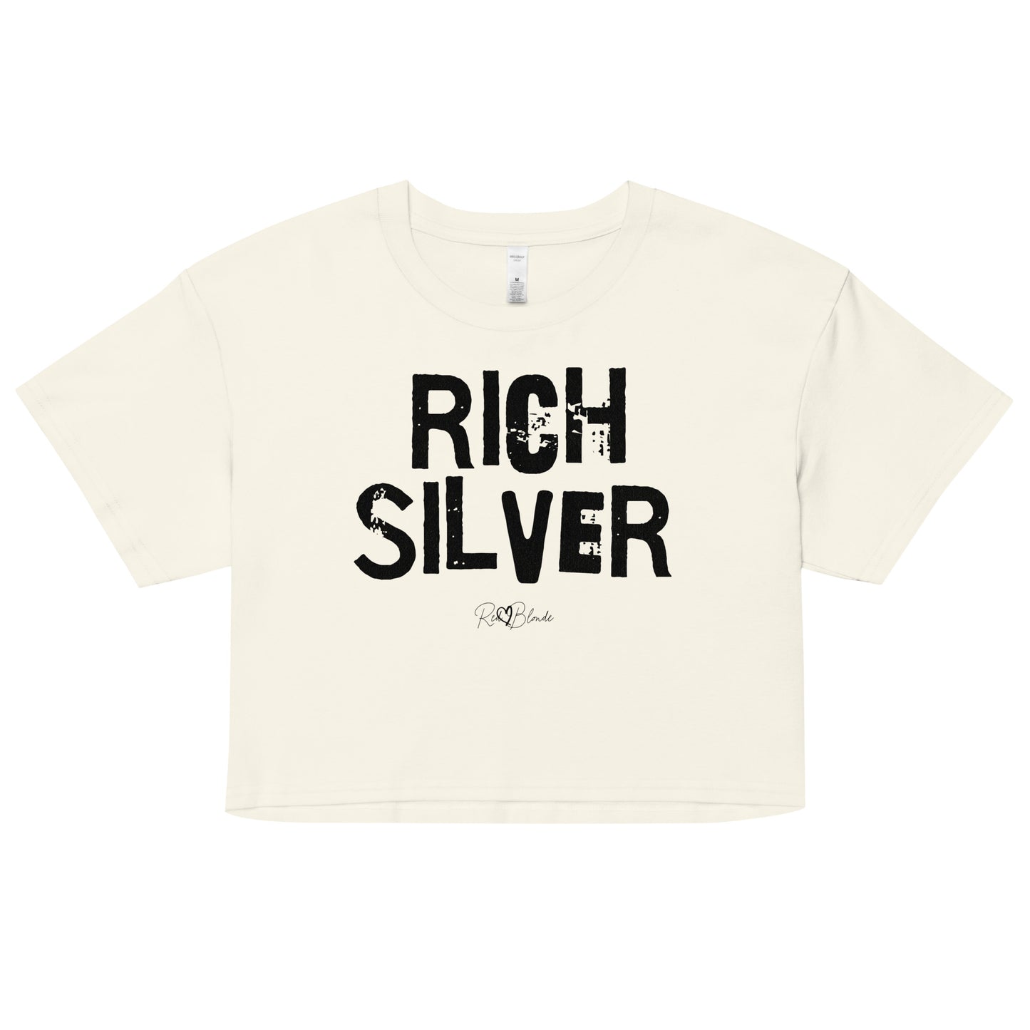 a natural coloured crop top with a relaxed fit, short sleeves, and a wide crew neckline. The front features bold black distressed lettering reading “RICH SILVER” with the RedBlonde signature logo underneath in black