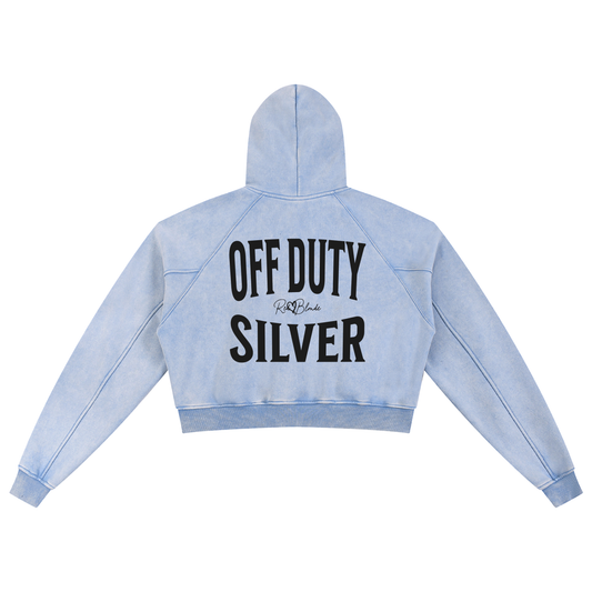 “Back view of a pale blue cropped hoodie with a hood and long sleeves, featuring large black ‘OFF DUTY SILVER' text and a small RedBlonde logo on the back.”