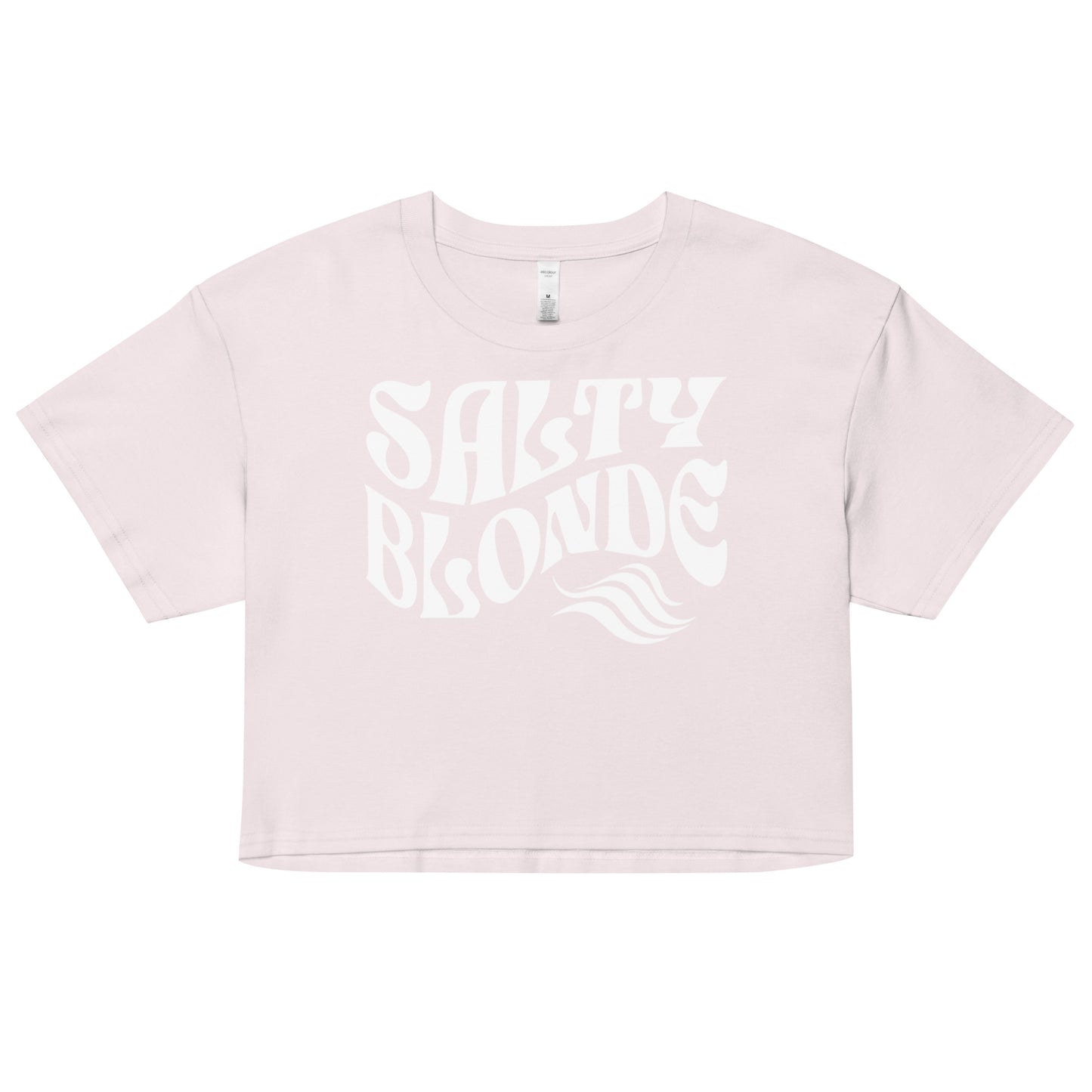 Flatlay of a pale pink orchid loose crop top t-shirt with the words ‘Salty Blonde’ in white retro 70s wavy font