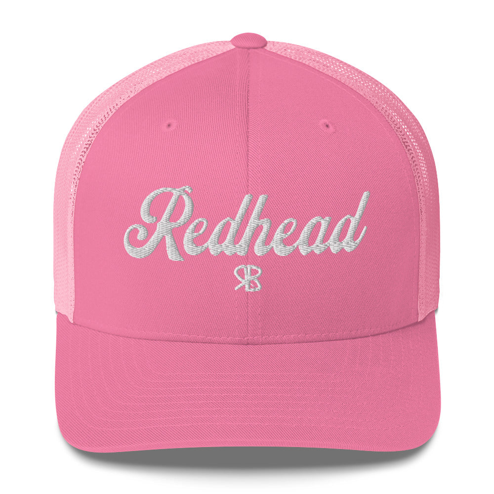 pink trucker cap with 'Redhead' in white adventurer 01 font on front. Mesh back. Branded RB
