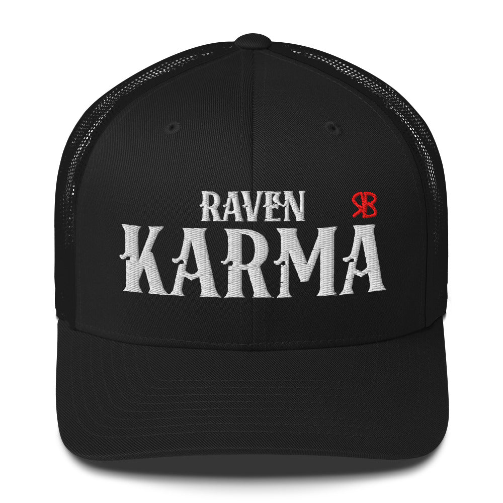 black retro trucker cap with mesh back. The front features bold white embroidered text reading "RAVEN KARMA" with a small red RB logo to the right.